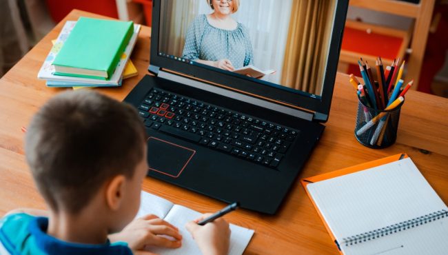 Kid attending school virtually on laptop